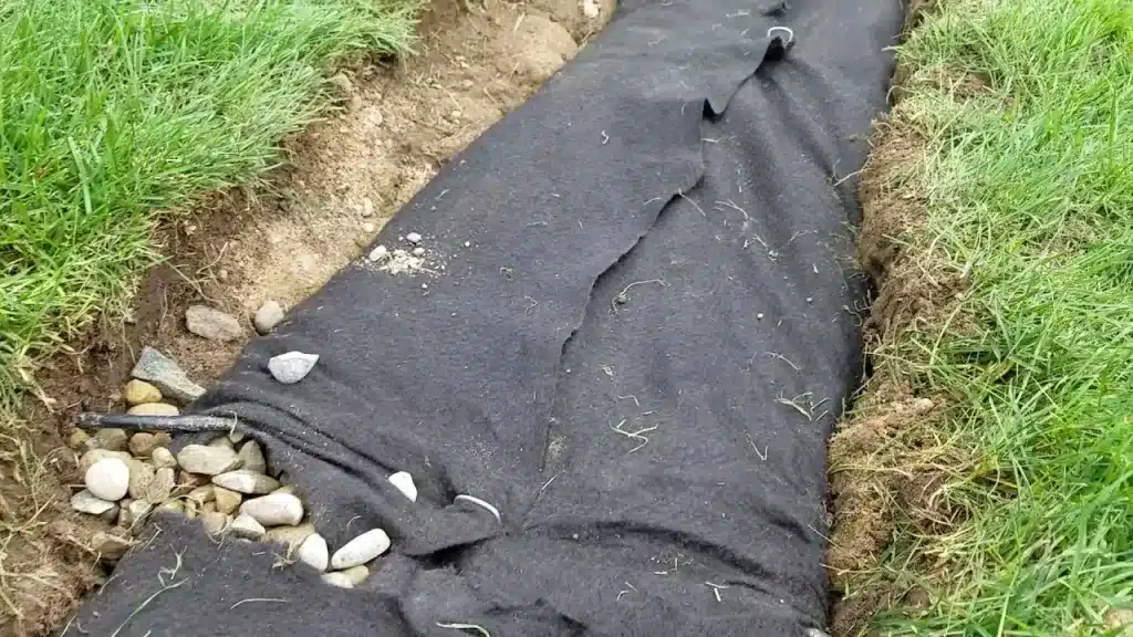 Woven landscape fabric installed in a commercial landscaping project with planting beds and ground cover