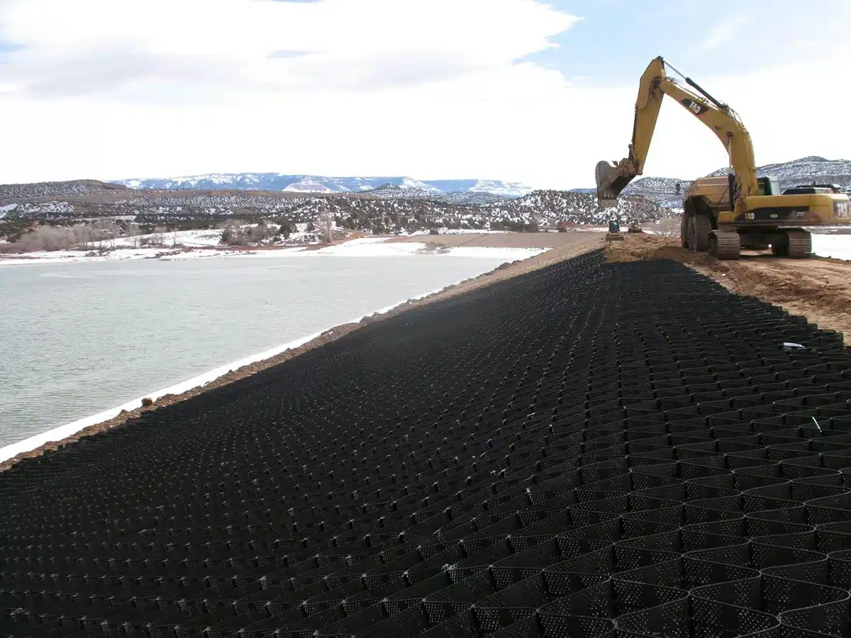 Geocell stream crossing with concrete infill providing erosion protection and load support in flowing water
