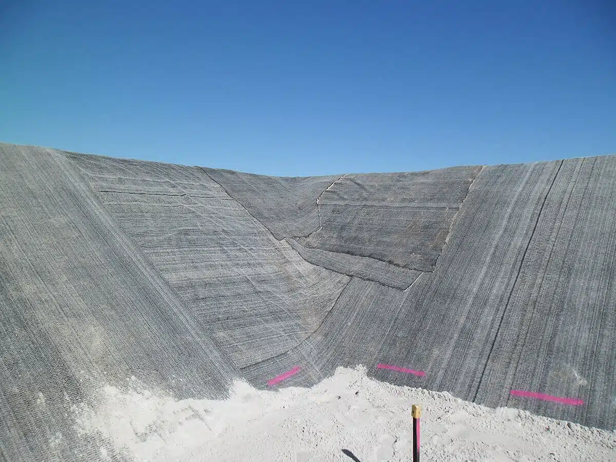Geosynthetic clay liner installation showing bentonite clay layer and geotextile materials
