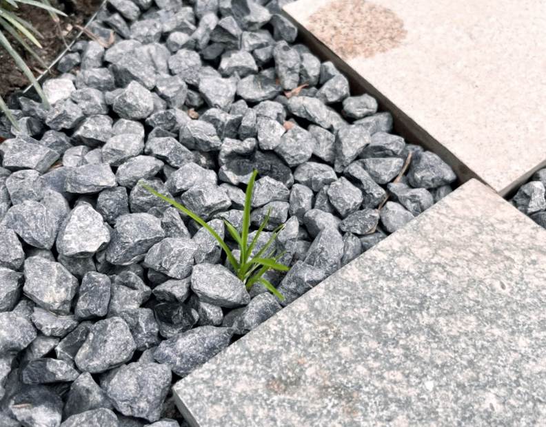 Landscape project using geotextile fabric under gravel for weed control, drainage, and long-term gravel stability.