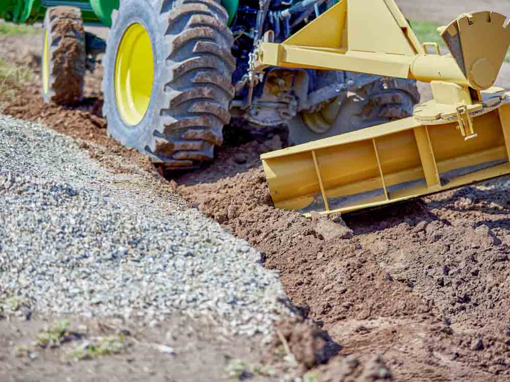 Geotextile fabric under gravel installed beneath a gravel driveway to improve soil stabilization, drainage, and aggregate separation.