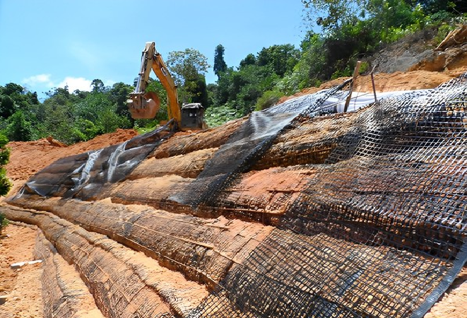 Construction site applying geogrid roll for slope reinforcement
