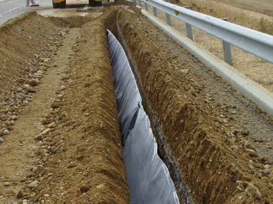 Instalación de geocomposite draintile en una carretera para mejorar el drenaje subterráneo