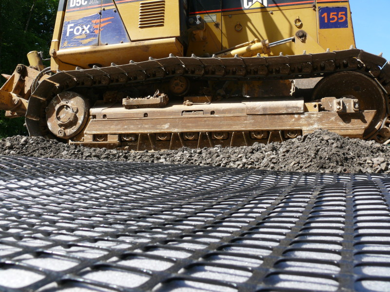 Installation of geogrid reinforcement on highway construction site