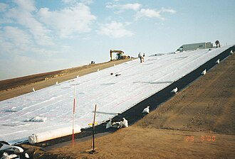 Sección transversal de un geocomposite drain instalado detrás de un muro de contención