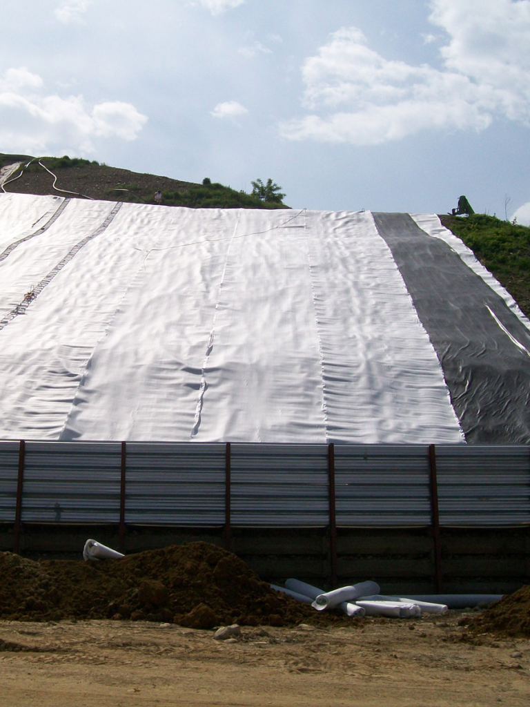 Sección transversal de un geocomposite drain instalado detrás de un muro de contención