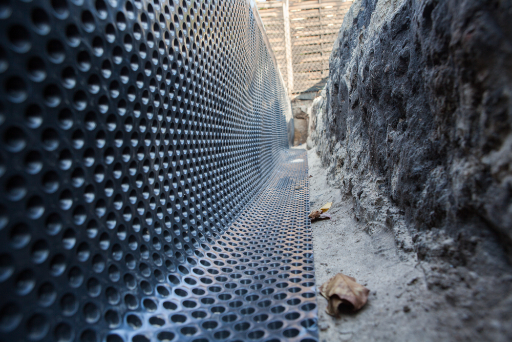 Sheet drain installation against building foundation wall for waterproofing and drainage
