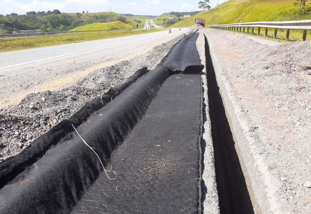 Geocomposite pavement drainage outlet pipe system in roadway construction