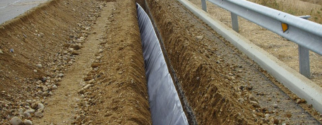 Retaining wall construction project with geocomposite drainage layer drainage solution