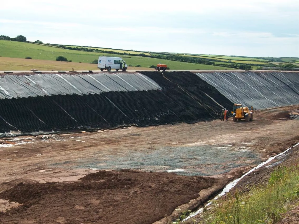 Geotextile wall erosion control system protecting embankment from soil loss