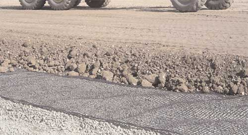 Geogrid fabric for roads installed to stabilize road subgrade and improve foundation strength